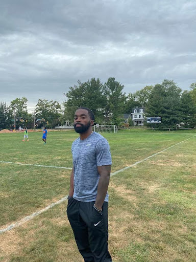 Soccer Coach Brandon Milbourne leading practice on Varsity Field.