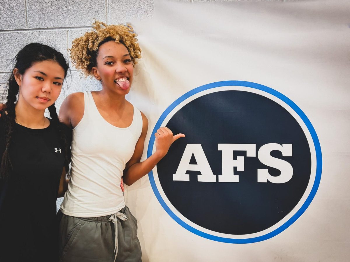 Christine Lahtaw '26 and Ella Hawkins '26 in front of the AFS logo