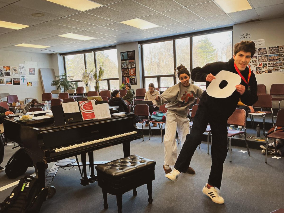 Two of AFS' Music Society Clerks, Ashya Farahi '26 and Theo Parker '26 jumping for joy at their weekly club meeting