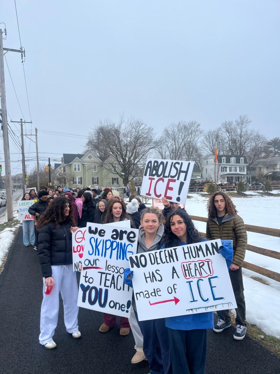 Students holding posters they created for AFS' walkout against ICE.