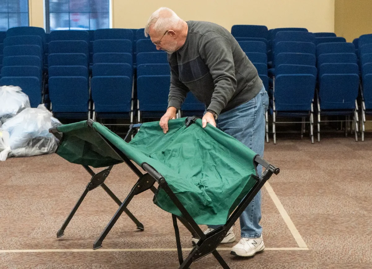 Volunteer sets up guest cot at the Norristown Code Blue Shelter