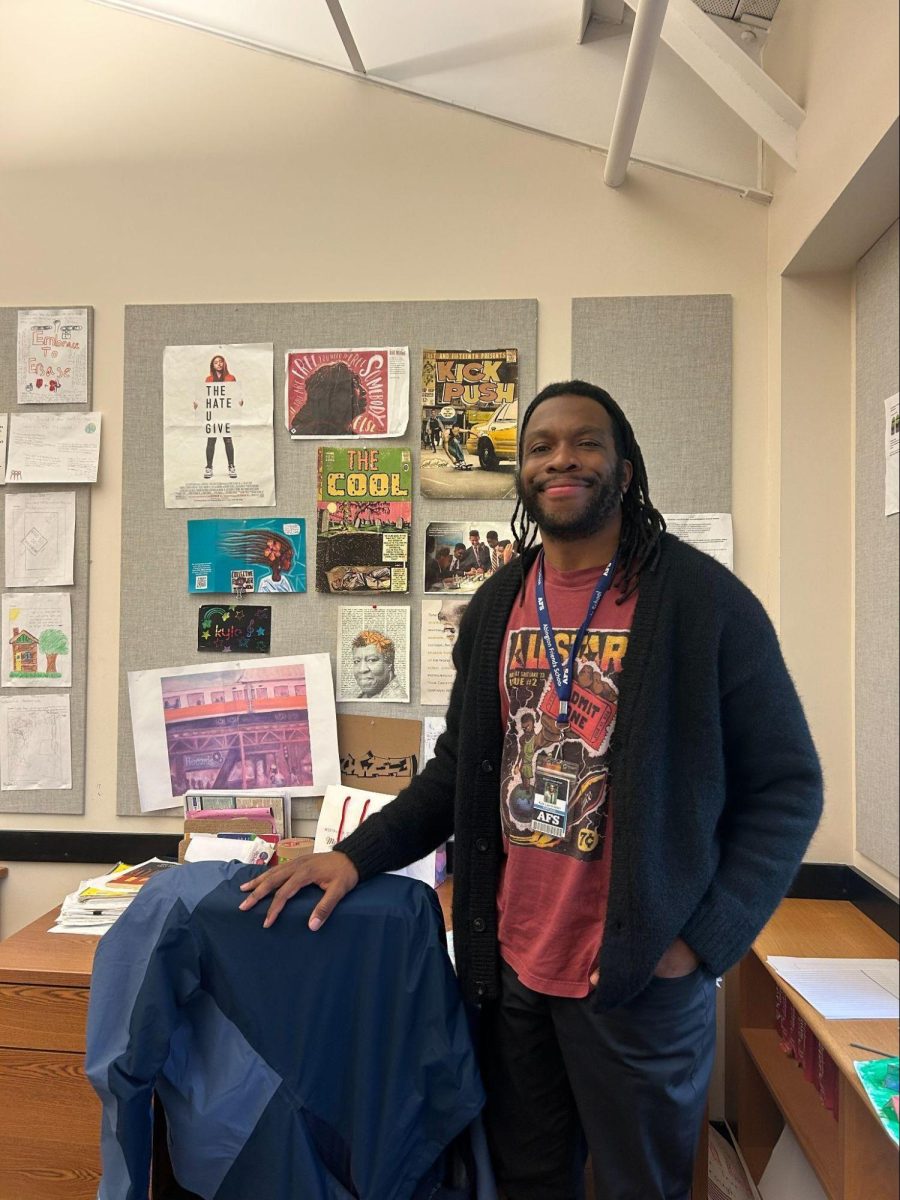 Kyle Layne-Allen, posing in front of his desk in his classroom.
